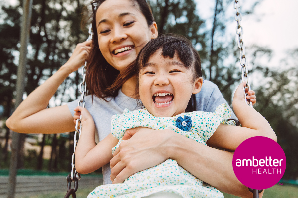 mom embracing daughter on swing